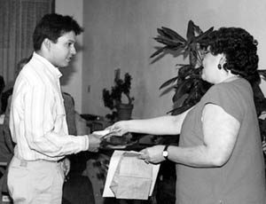 Michael receives an art award from Connie Mesquita, director, Multi-Cultural Center, c. 1988.
