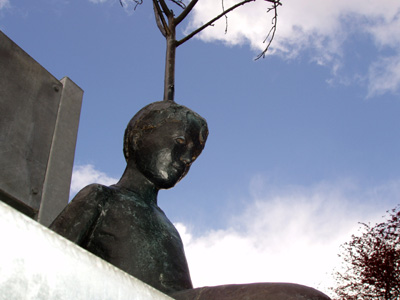 'Conception of Creation' a bronze sculpture by Roger Williams, depicts a small boy with a tree growing out of his head sitting on a giant chair 