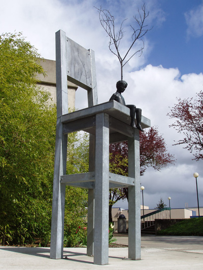 'Conception of Creation' a bronze sculpture by Roger Williams, depicts a small boy with a tree growing out of his head sitting on a giant chair 