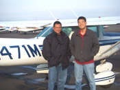 Two men standing in front of a plane