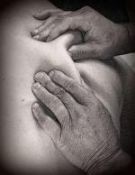close up of person's hands, giving table massage on the back