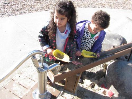 two girls playing in sand