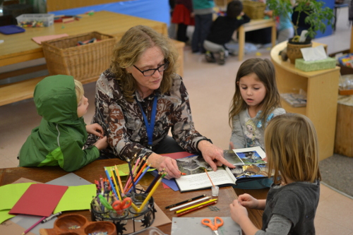 teacher and children reading a book