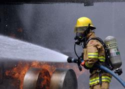 Fire fighter wearing gear to put out fire