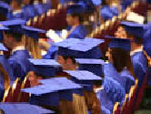 graduates in caps and gowns, seated waiting for graduation to begin