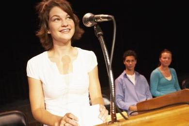 woman speaking to group on stage