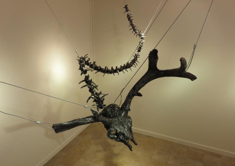 Hanging cast metal of animal vertabrae and skull