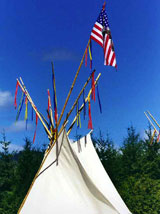 View of the top of a tee-pee with a flag.