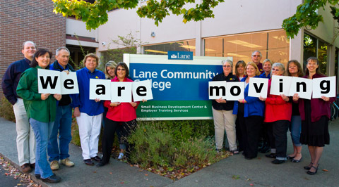 Small Business Development Center staff holding letters to spell 'we are moving'