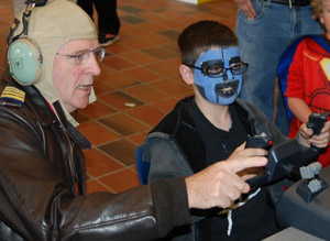adult and child in costume at the flight simulator