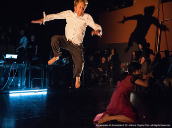 man spotlighted mid air on stage