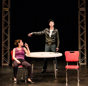 two on stage, one at table, another standing in leather jacket