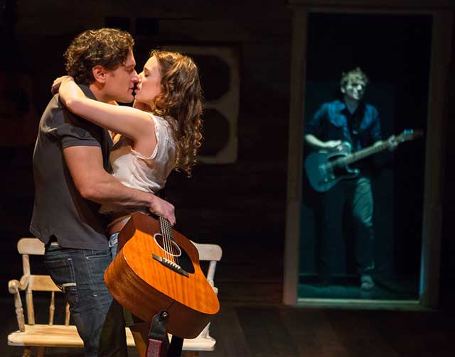 image of actors embraced onstage, with onlooker