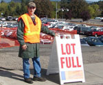Facilities staff standing next to Lot Full sign near main campus parking lot