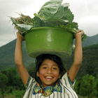 young girl with basket of vegetables on her head
