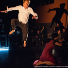 man spotlighted mid air on stage