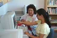Native American student getting help from on a computer.