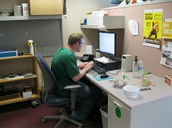 A young man is entering information on a computer
