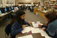 two students sitting at table working on homework