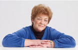 Woman with red hair and blue sweater smiling at camera