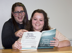two students looking at book together